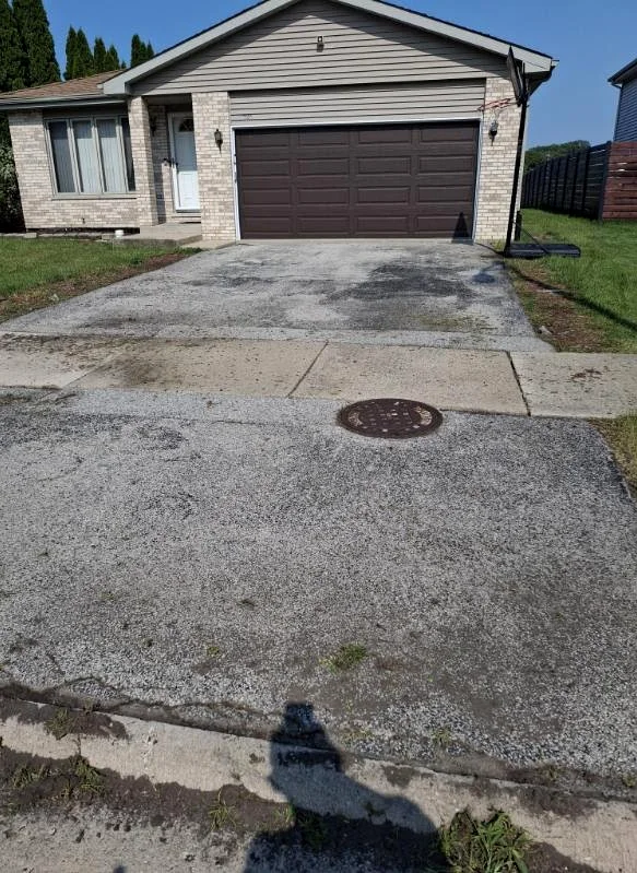 Residential driveway before asphalt surface refresh