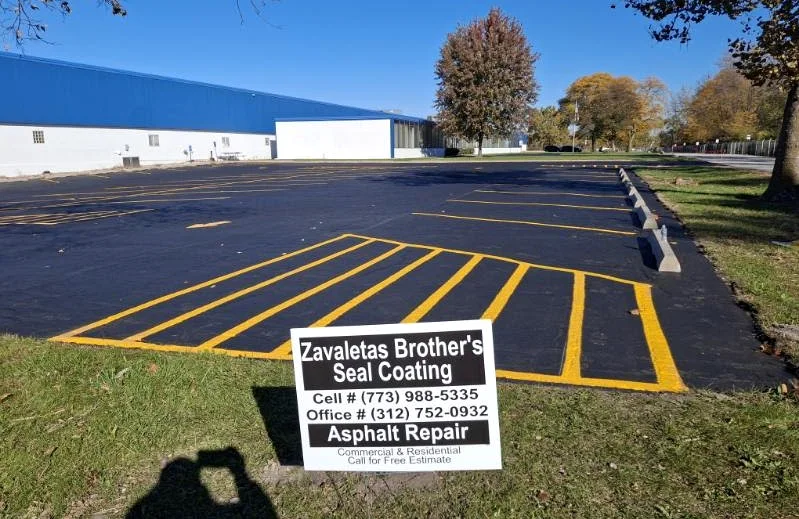 Completed parking lot seal coating and striping with Zavaleta Brothers sign